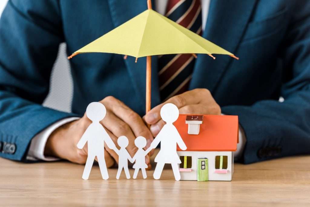 Whole Life Insurance Vs. Universal Life Insurance male hands with paper cut family house model and umbrella on wooden table life insurance 1024x684 - Whole Life Insurance Vs. Universal Life Insurance